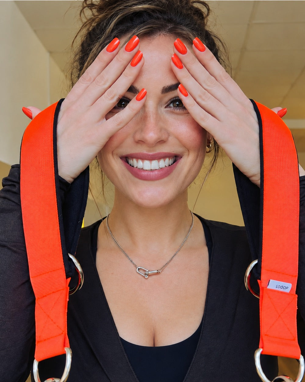 Trainerin mit orangen LOOOPS über den Schultern